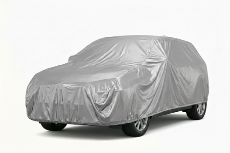 Car covered with a silver car cover on a white background