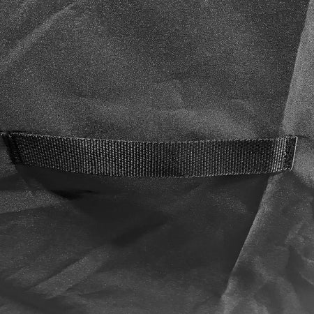 Close-up of a black textured fabric item with a horizontal black elastic or hook-and-loop style band across the middle.